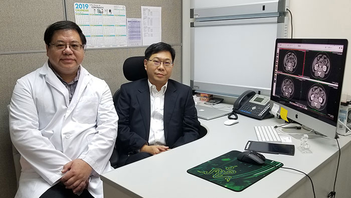 Mr. Tang and Dr. Lo sitting next to each other behind a desk.