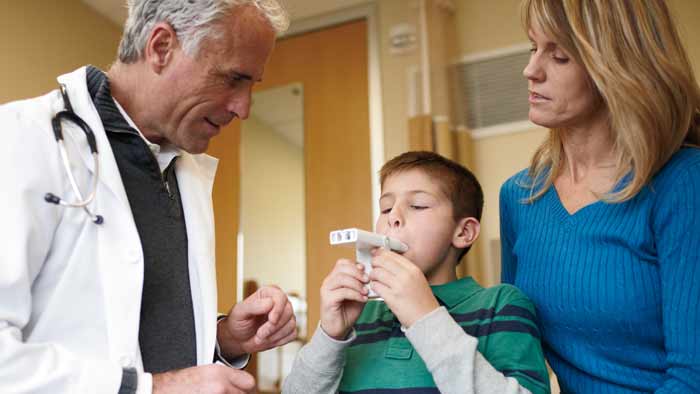 zdravstveni djelatnik pomaže djetetu s proizvodom za astmu
