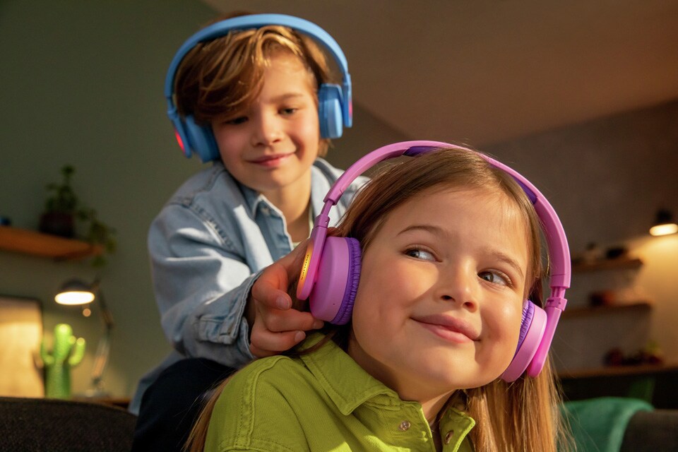 Dvoje braće i sestara igraju se dok koriste slušalice za djecu