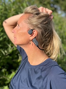 Žena nosi bluetooth slušalice tvrtke Philips koje zvuk prenose preko kostiju