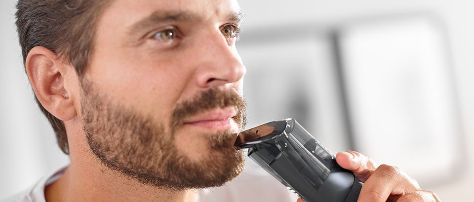 Man trimming beard with Philips beard trimmer